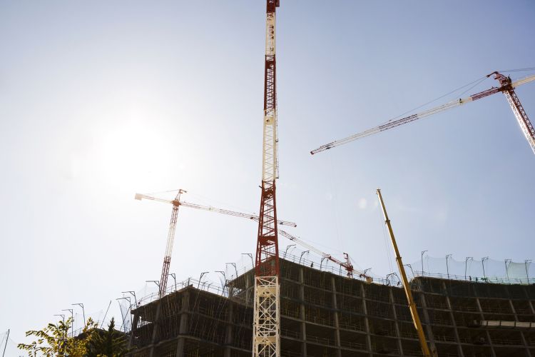 silhouette-buildings-construction-against-blue-sky-sunlight-min